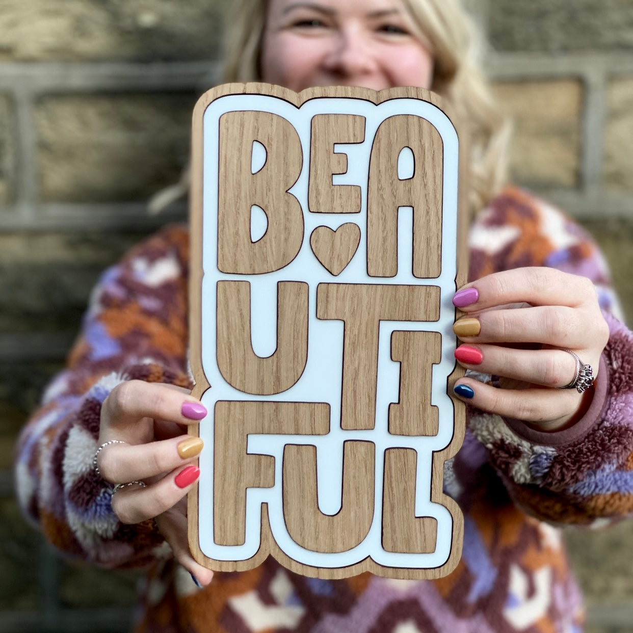Wooden laser cut wall art featuring a hand drawn font saying 'beautiful'